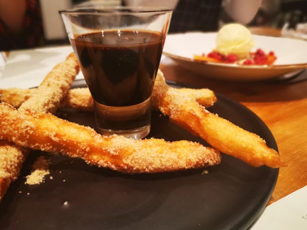 Vegan cinnamon churros with chocolate sauce.