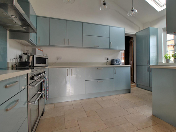 The modern, high-gloss kitchen has space for a range cooker and an integrated dishwasher, with a bright, airy breakfast room attached.