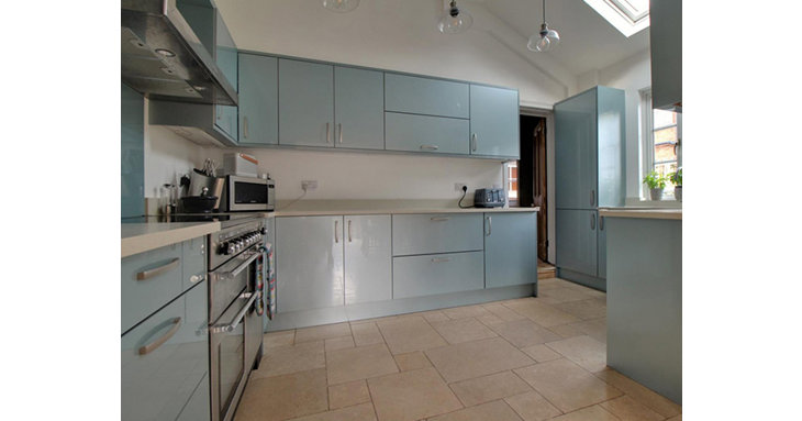 The modern, high-gloss kitchen has space for a range cooker and an integrated dishwasher, with a bright, airy breakfast room attached.