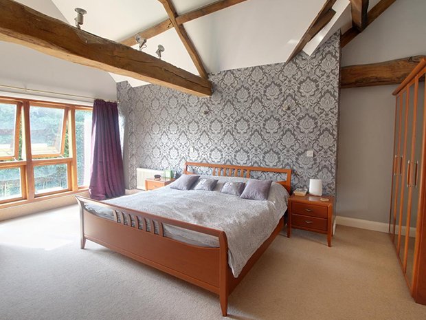 The large master bedroom is flooded with natural light from the full-width windows and benefits from an ensuite shower room too.