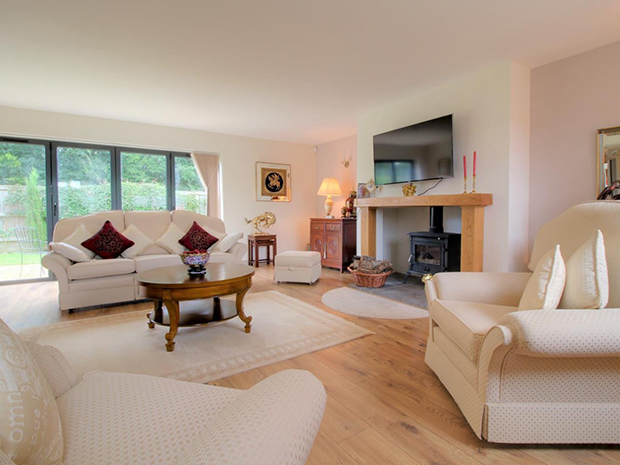 A traditional wood burning stove gives the bright, spacious living room a cosy feel.
