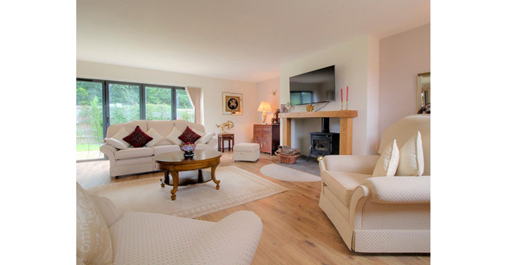 A traditional wood burning stove gives the bright, spacious living room a cosy feel.