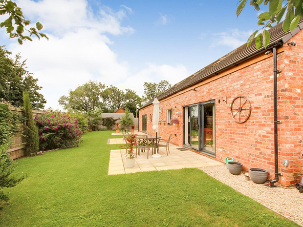 Bi-fold doors from the lounge and kitchen lead out to a large, well-kept garden with paved patio areas ideal for alfresco entertaining.