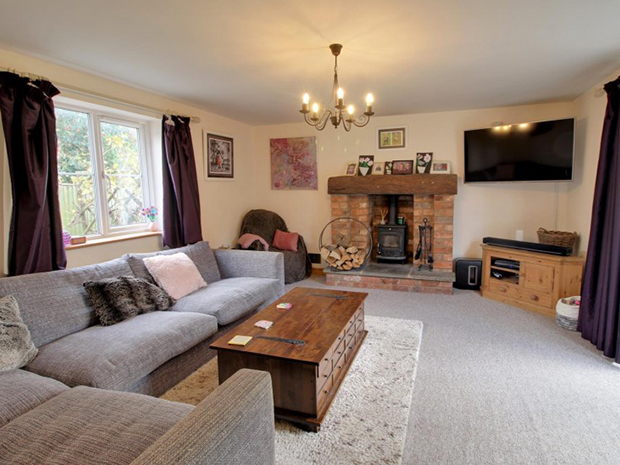 The spacious lounge features a wood burning stove and French doors to the garden.