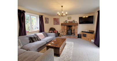 The spacious lounge features a wood burning stove and French doors to the garden.