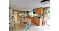 The spacious kitchen has room for a family dining table, as well as French doors out to the patio for alfresco dining.