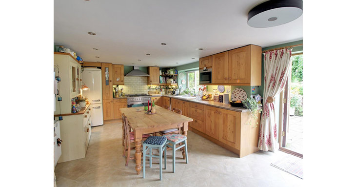 The spacious kitchen has room for a family dining table, as well as French doors out to the patio for alfresco dining.