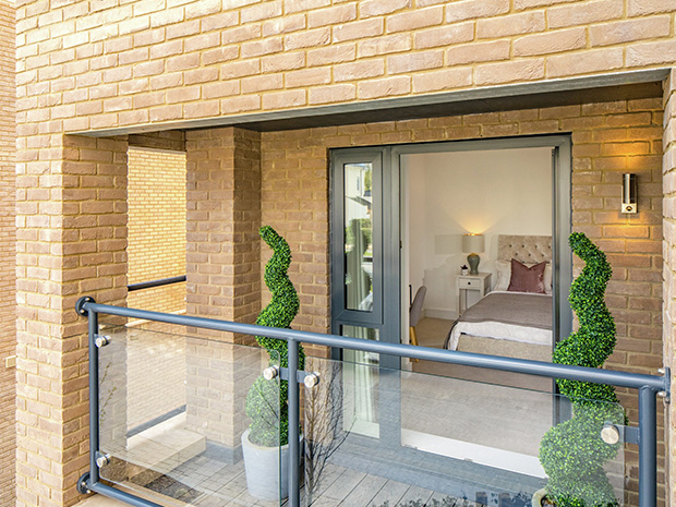 The balcony is serviced by a powder-coated aluminium door, matching the contemporary style of the buildings windows.