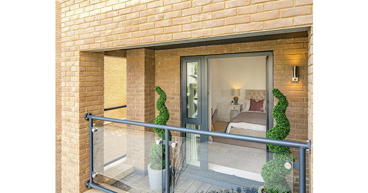The balcony is serviced by a powder-coated aluminium door, matching the contemporary style of the buildings windows.