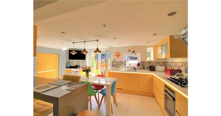 The bright, modern kitchen has a breakfast bar, Neff appliances and French doors out to a sunny courtyard.