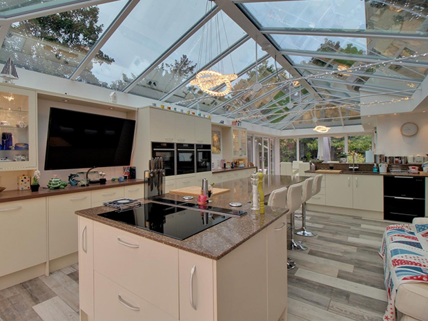 The kitchen, living and dining area features colour changing mood lighting, not to mention three ovens, integrated dishwasher and granite worktops as well as a central island and doors to the garden.
