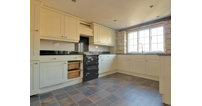 The kitchen is both traditionally charming and modern, with a range cooker and integrated appliances.