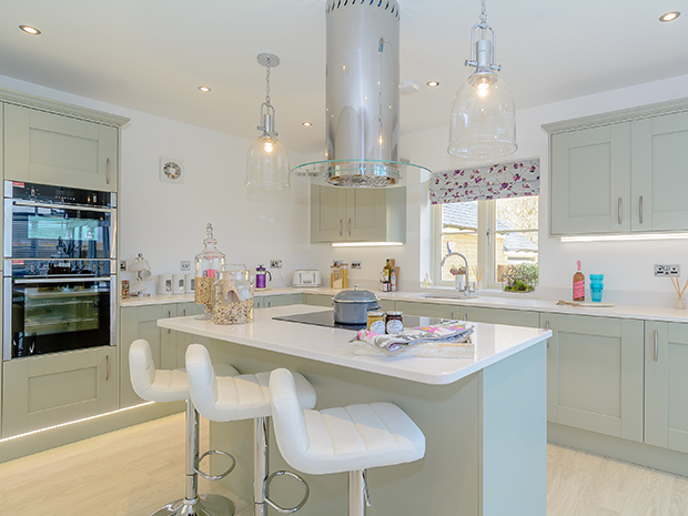 The bright kitchen dining area has a feature island, integrated appliances and silestone worktops.