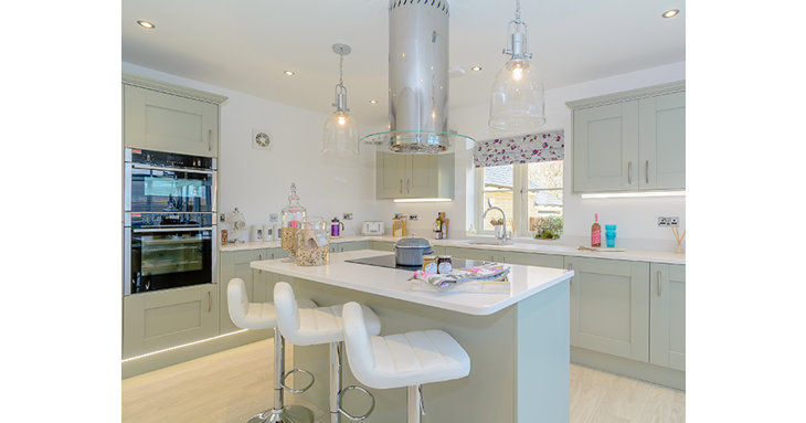 The bright kitchen dining area has a feature island, integrated appliances and silestone worktops.