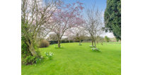 The property boasts two acres of grounds, including a mature orchard and pony-friendly paddock.