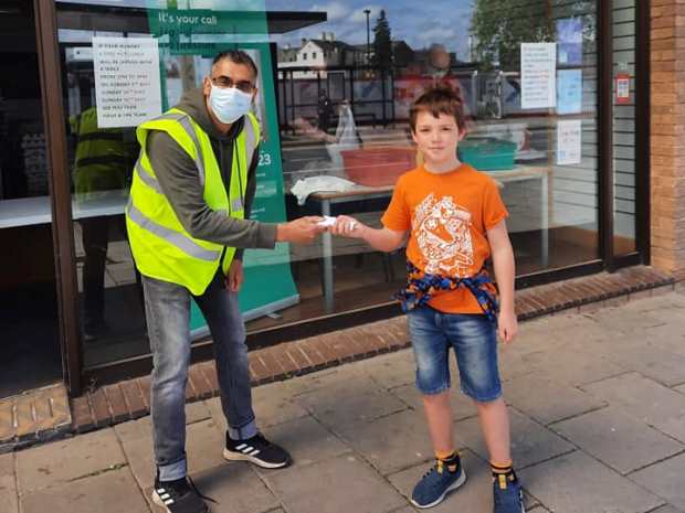 Nine-year old Arthur hands over the 80-plus he raised with his family for Gloucester Feed the Hungry to Hash Norat outside the group's new city centre takeaway.