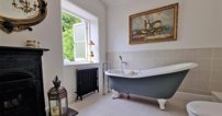 The family bathroom has a slipper bath, ideally positioned with views over the garden, as well as a separate shower with rainfall head - and a working fireplace.