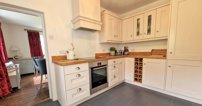 The kitchen blends a traditional look with plenty of modern conveniences, including an integrated fridge freezer, dishwasher and oven.